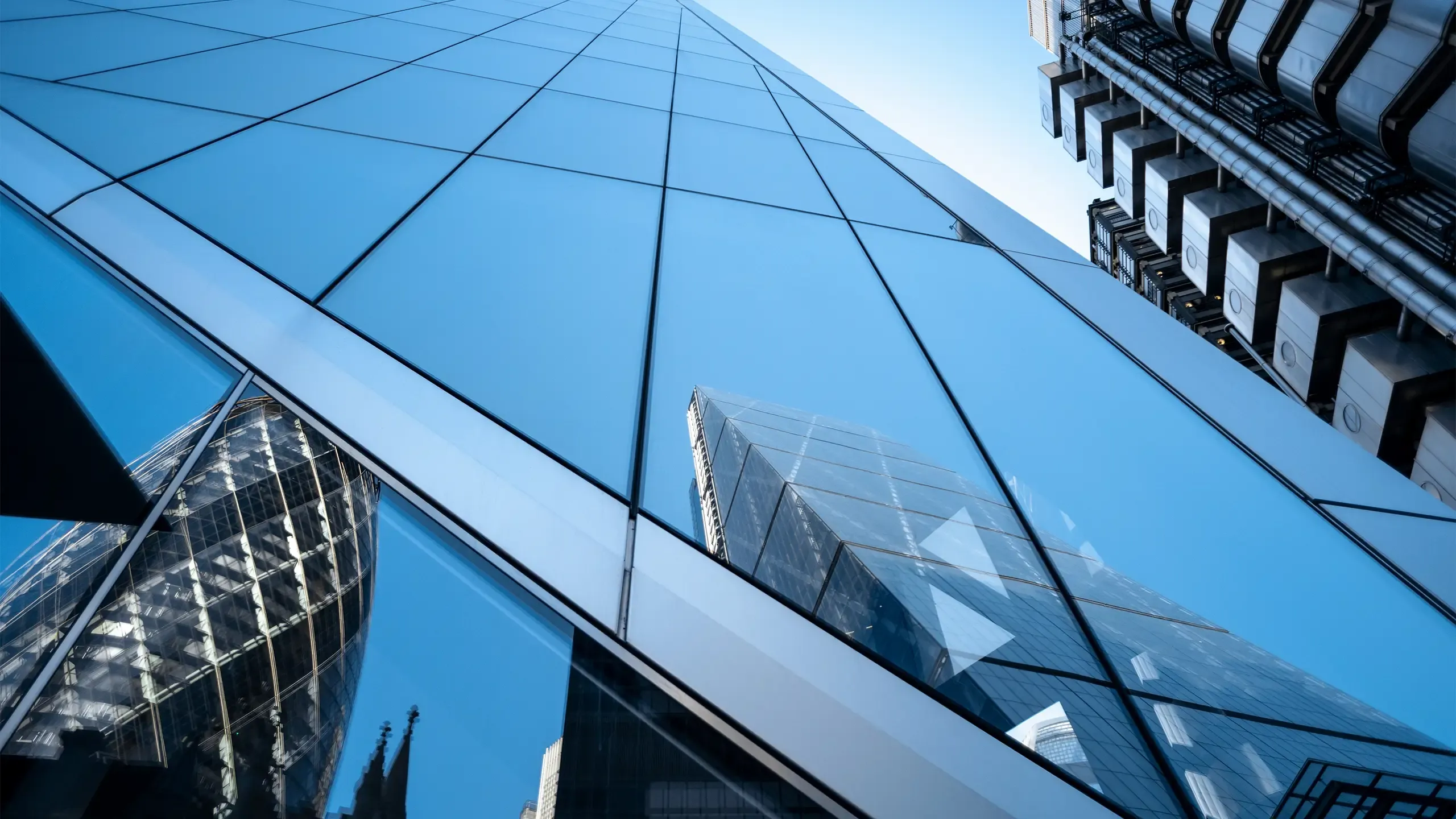 UK, London, reflection of office buildings in the financial district against clear sky